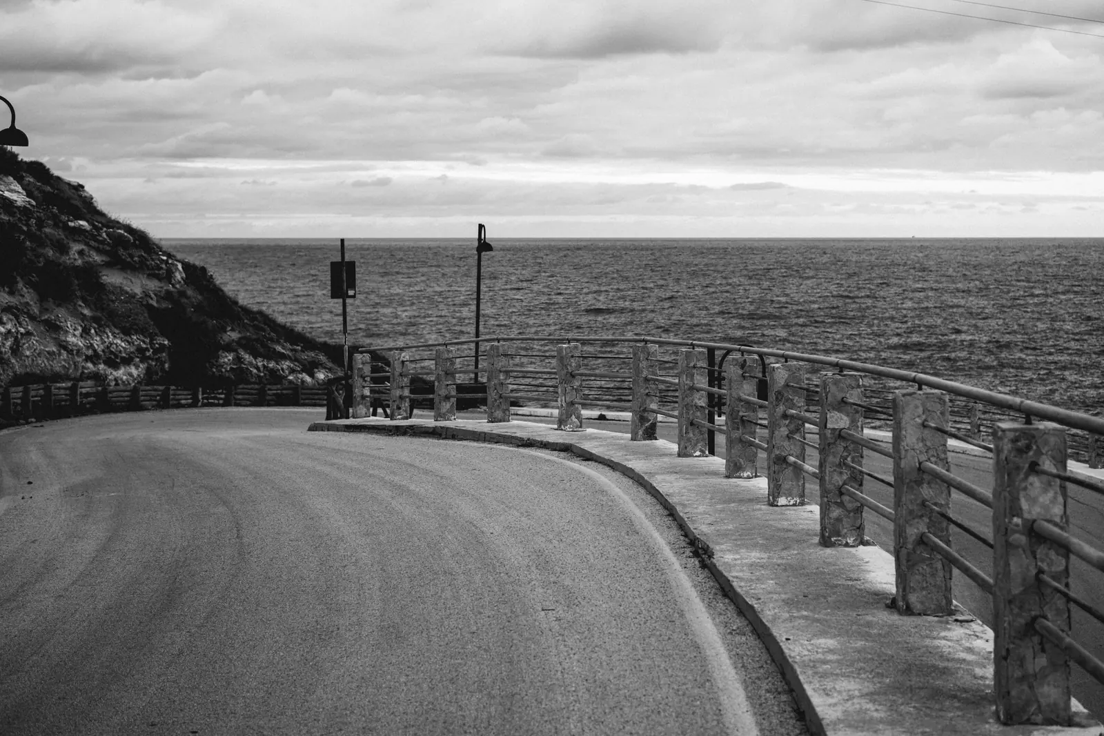Empty coastal road with a railing above the sea