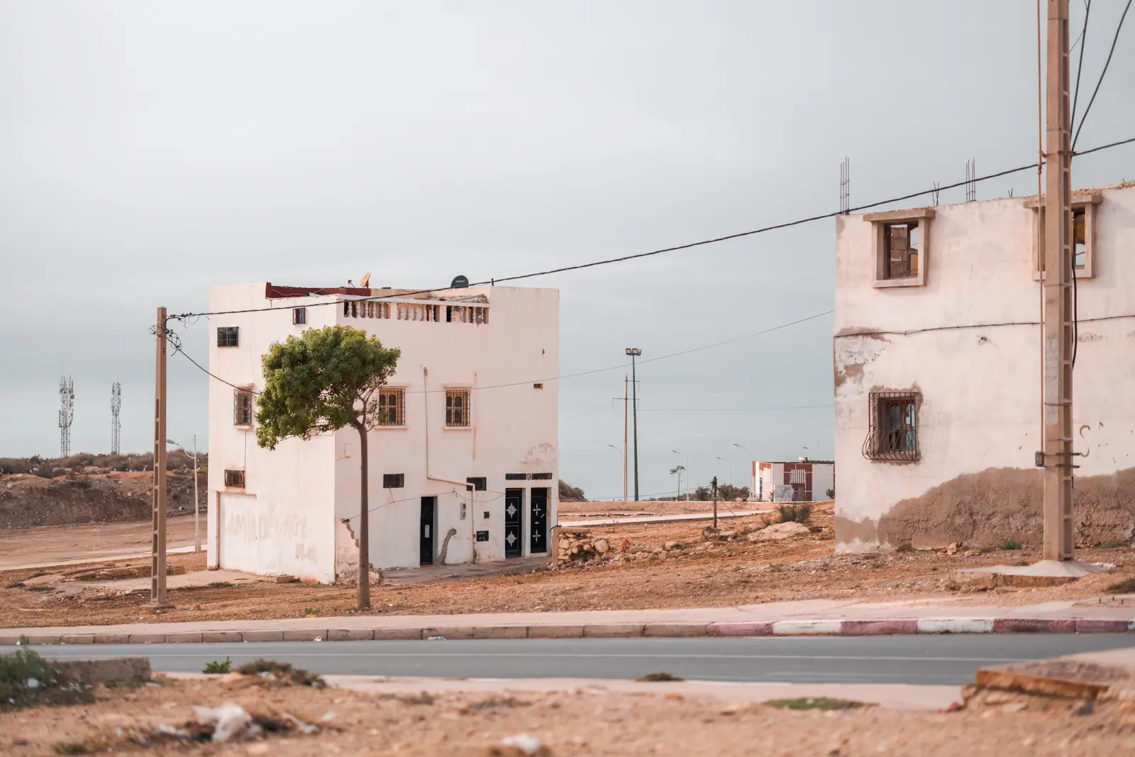 White houses and electricity poles on dry ground