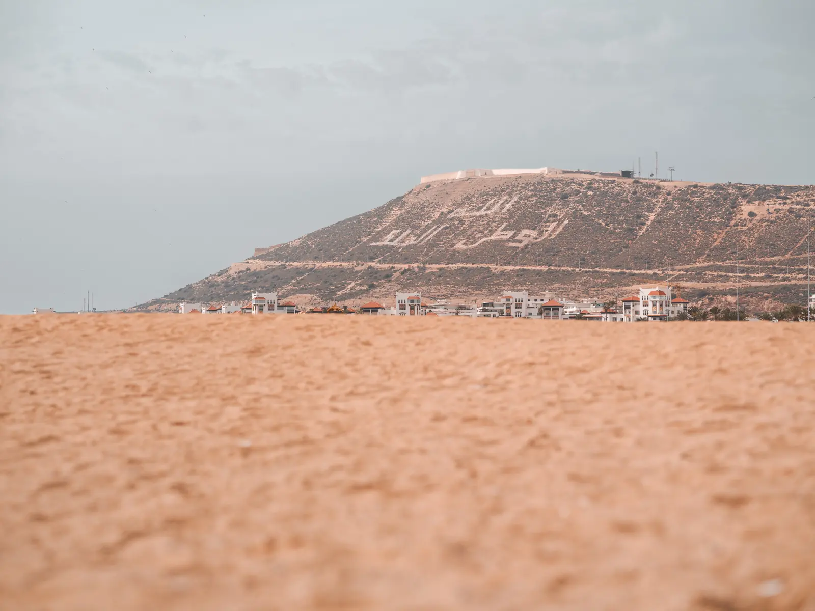 Sand in the foreground and the hill of Agadir Oufella