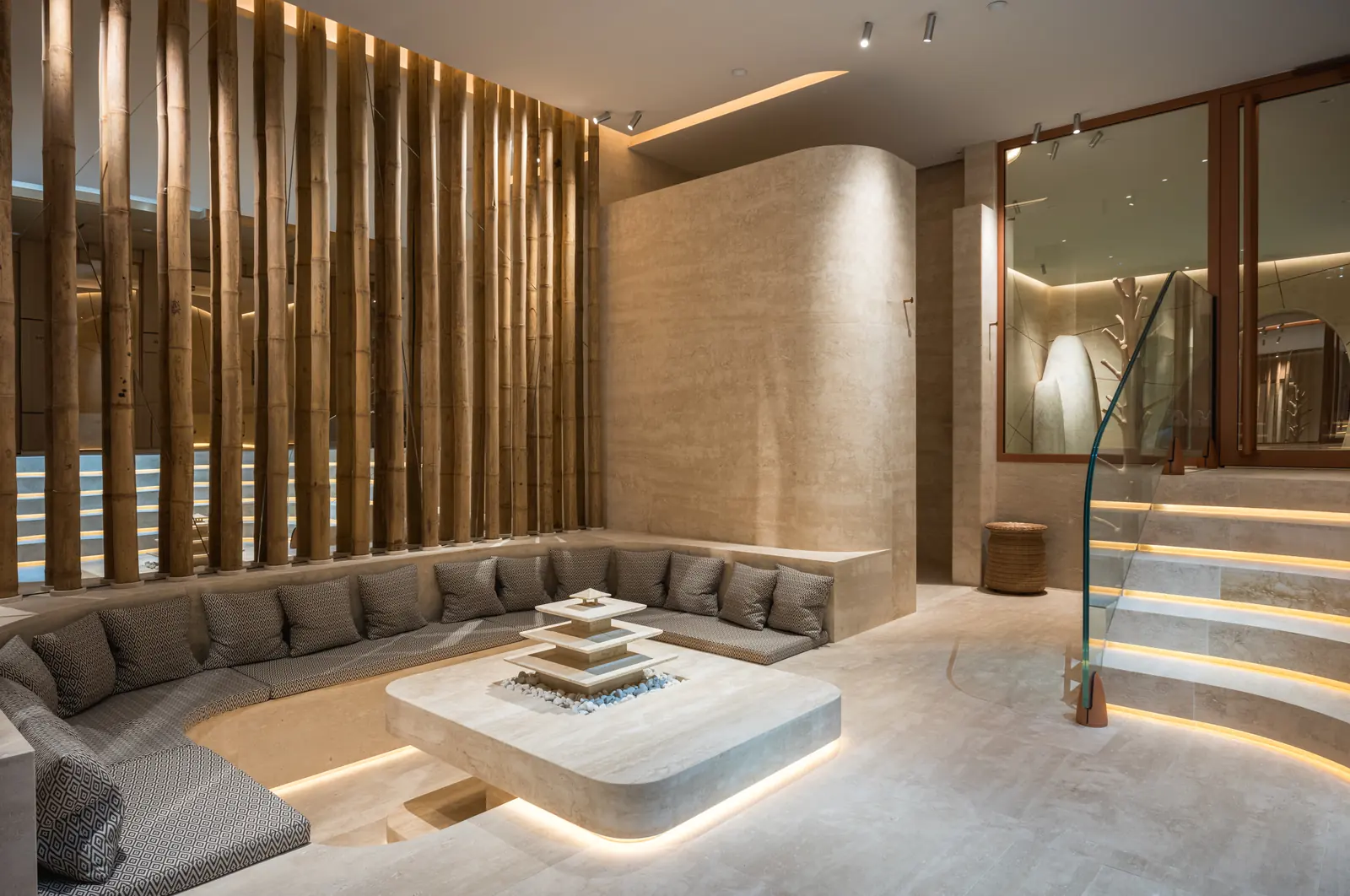 Spa lounge at Le Dix with sunken seating, timber screens and lit stone steps