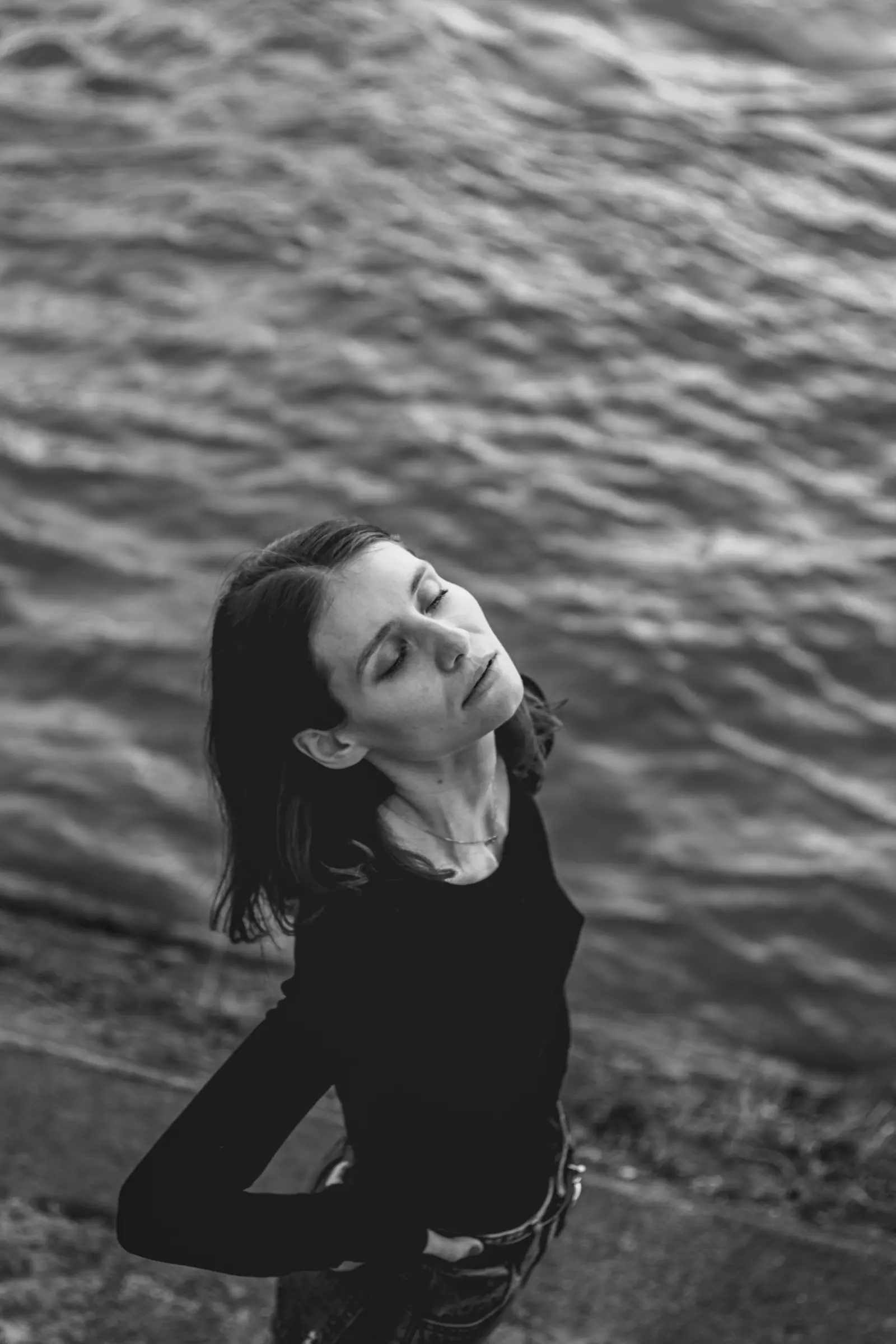 Woman with her eyes closed above the water, in black and white