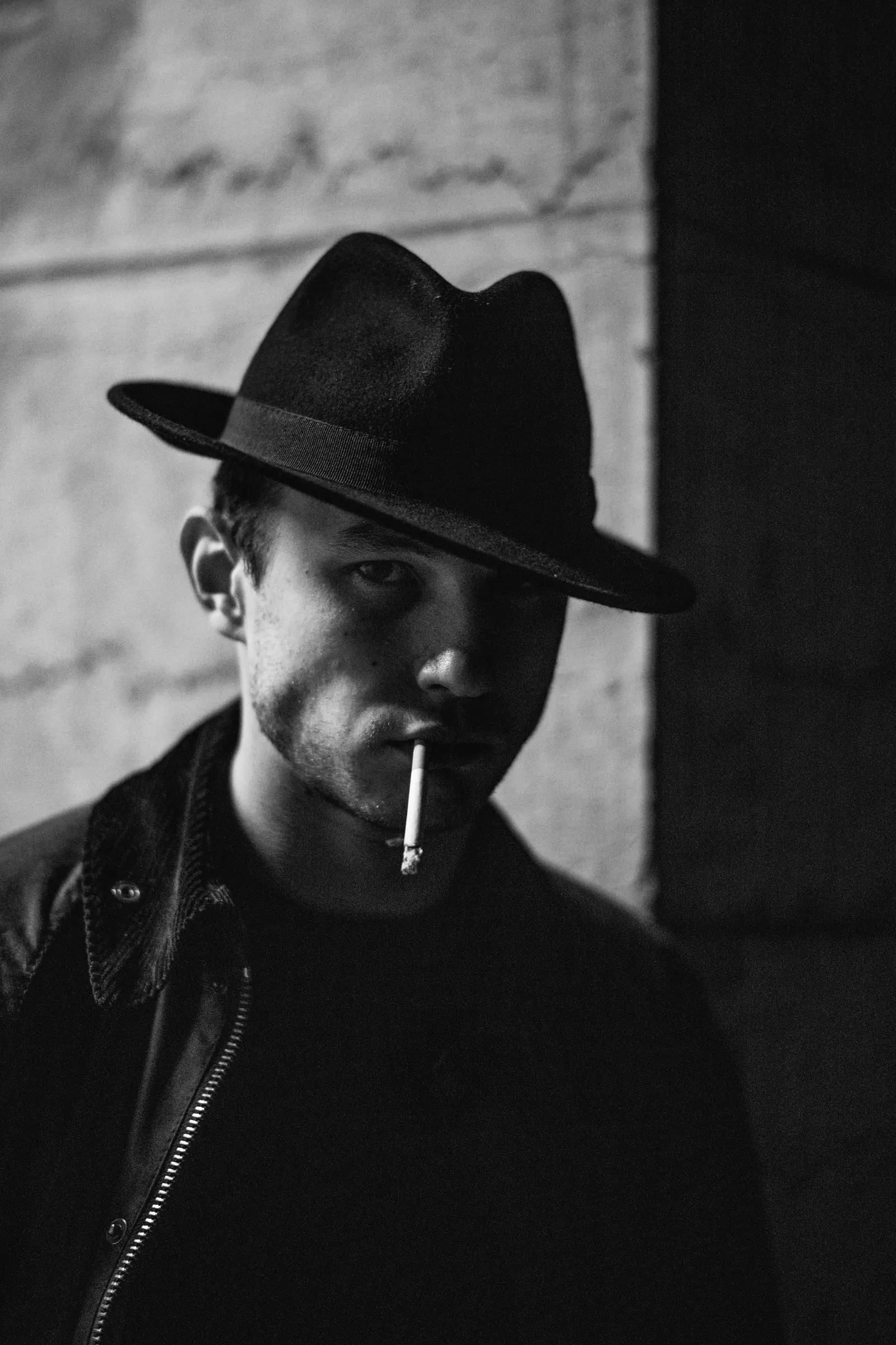 Man in a felt hat with a cigarette, in black and white