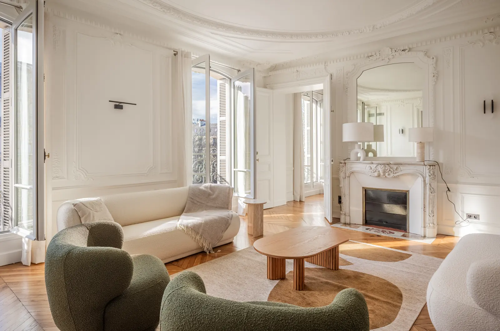Haussmann living room with a marble fireplace, mirror and green armchairs