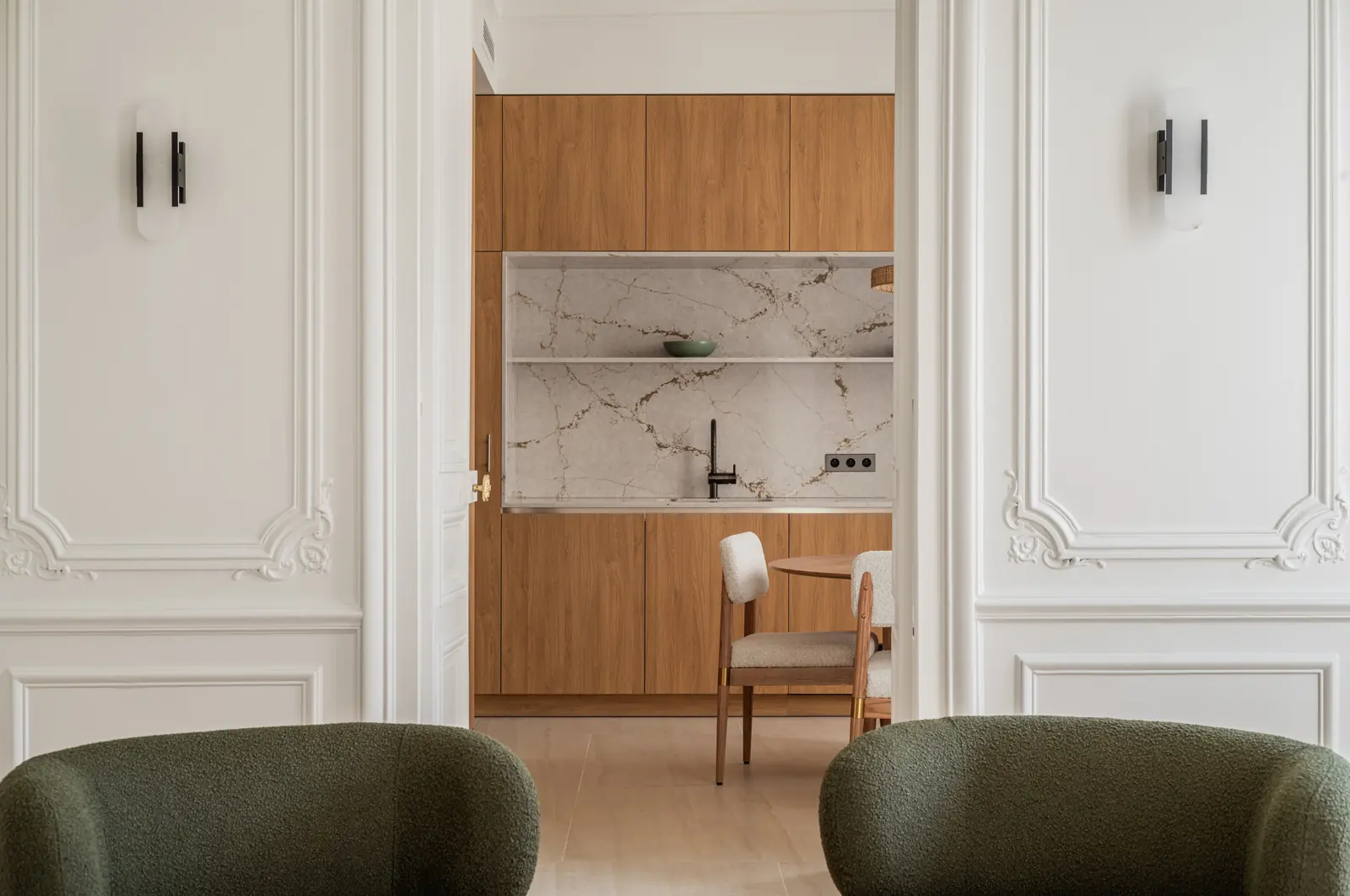 View through panelled double doors to an oak and marble kitchen