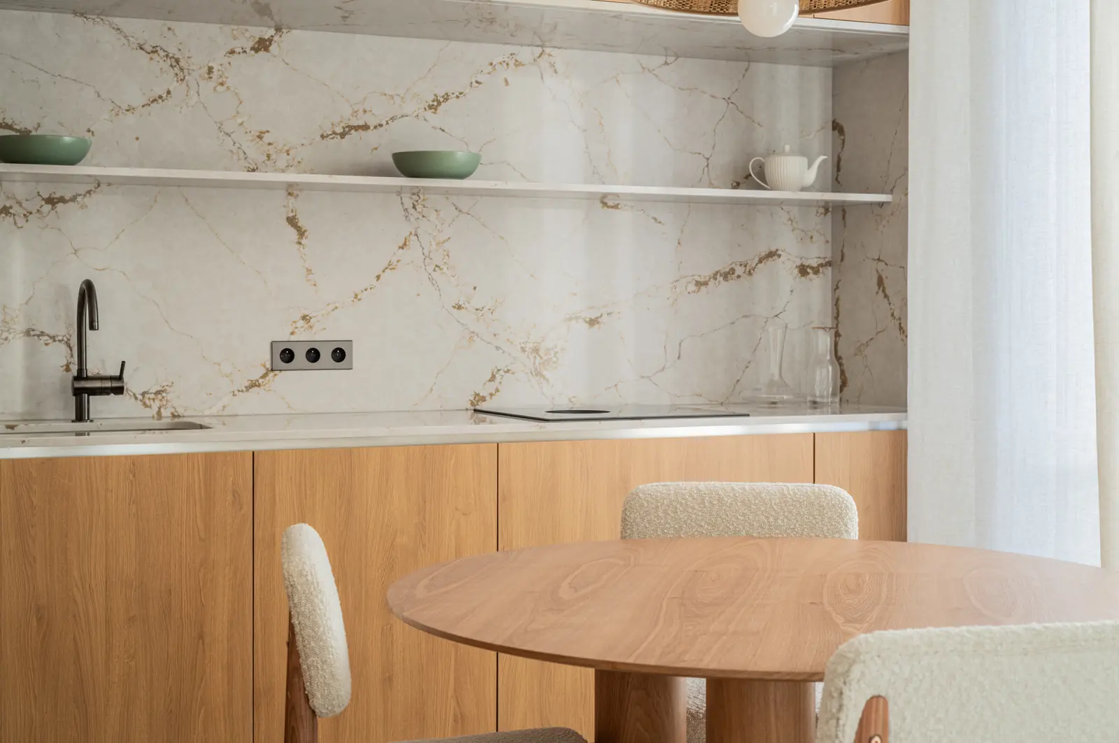 Kitchen with a marble splashback and a round oak table