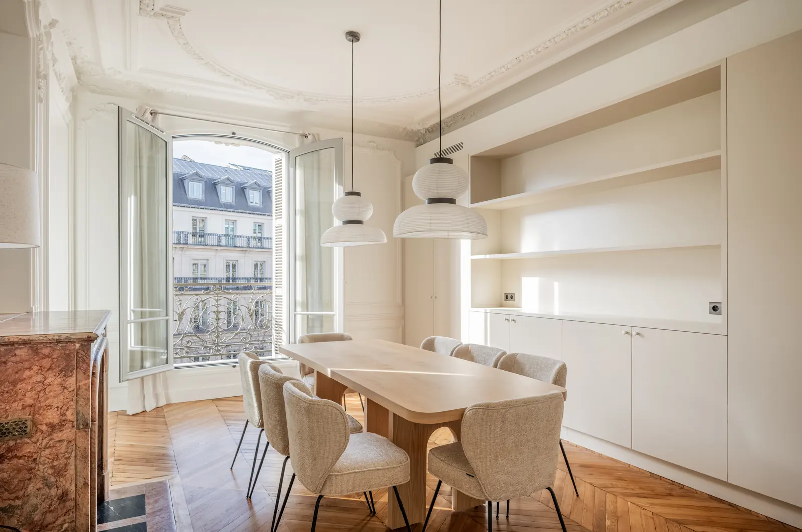 Dining room with open windows onto Paris rooftops