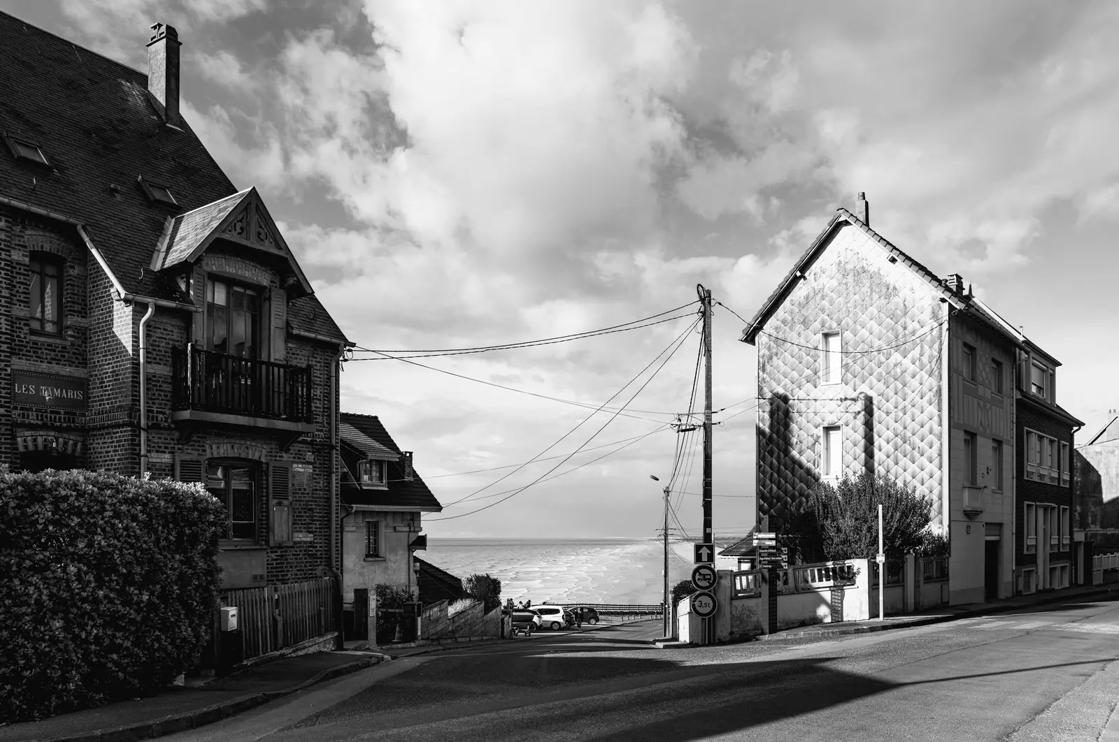 Villa and a house with a patterned gable, the sea behind
